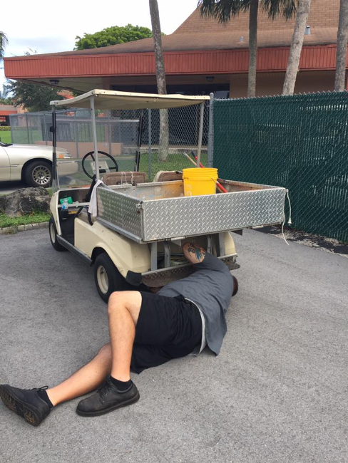 Technician performing mechanical repair and diagnostics on a golf cart motor